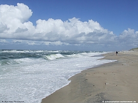 Ein Strand mit auflaufenden Wellen